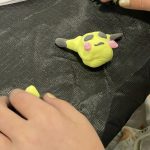 Small clay Pokemon craft on a black tablecloth