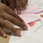 Close up of child's hands folding an origami heart